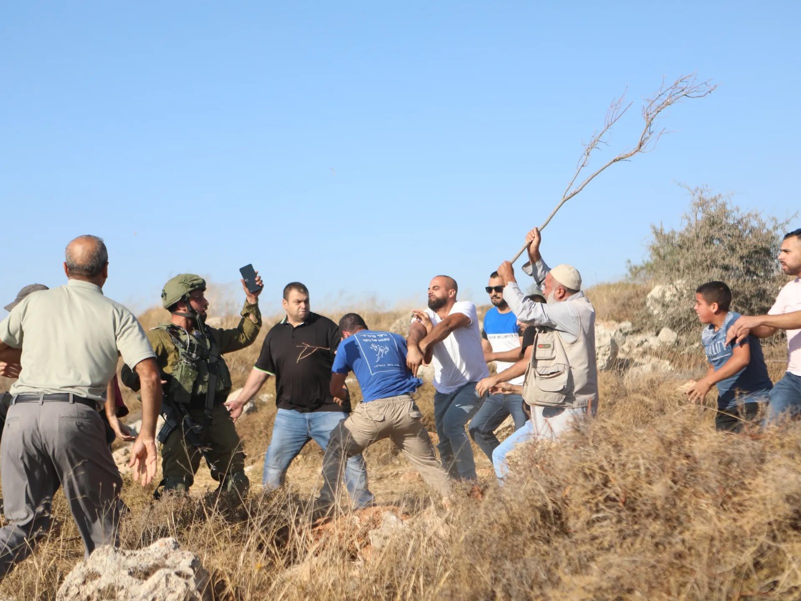 Unarmed civilians facing armed forces on West Bank land
